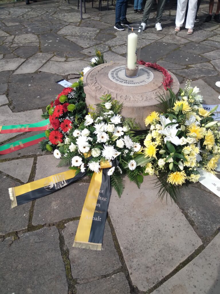 7_Nagasaki-Gedenkstein, Trümmerstein aus Nagasaki, mit Kerze und Blumengebinden_Foto Doris Döring